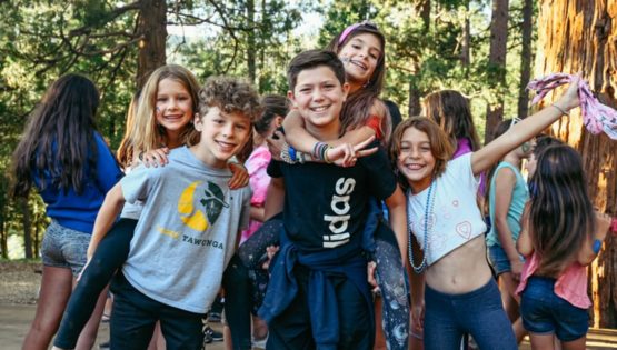 Campers giving piggyback rides and smiling