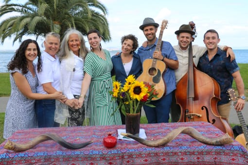 Adults at a year round event on beach with guitar