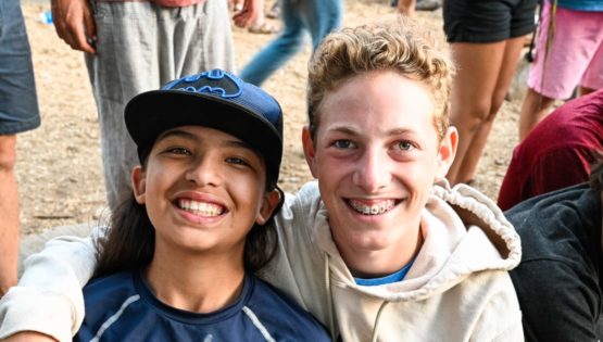 Young camper smiling with staff