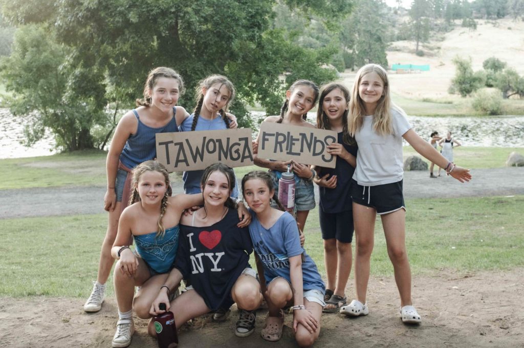 A group of happy girls holding a sign that says "Tawonga Friends".